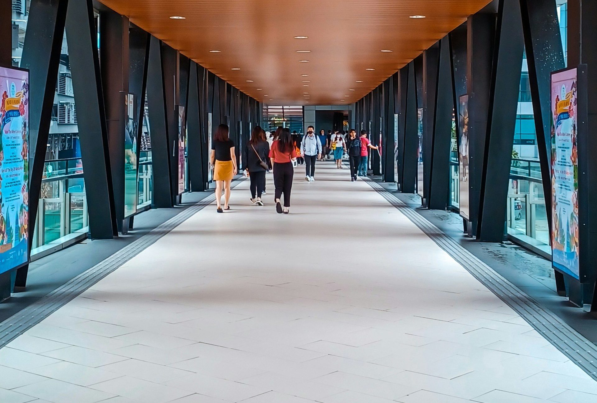 people walking in a large room with many computer screens